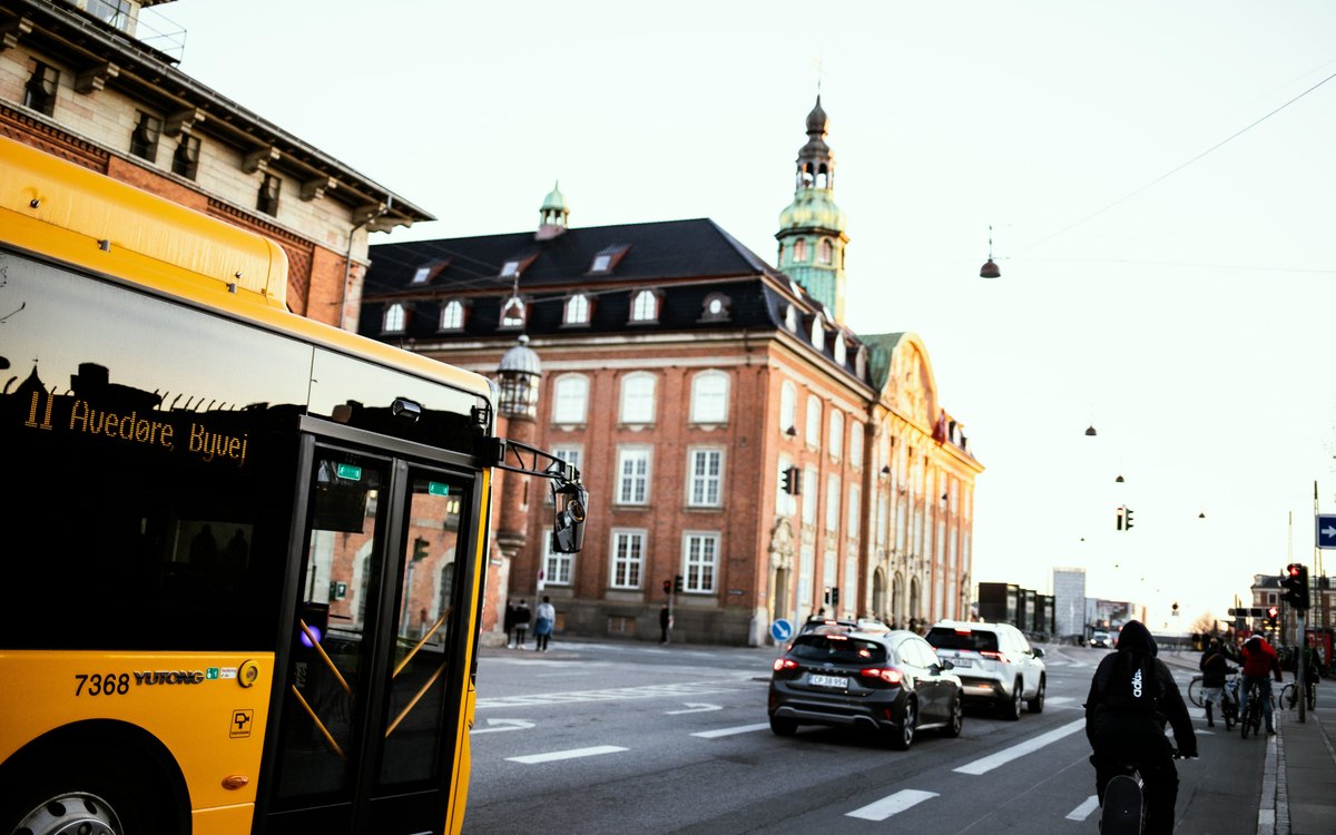Gul bybus, biler og cyklist i trafik i København